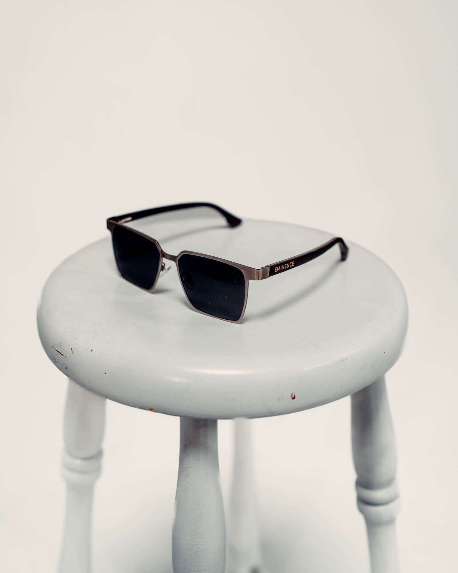 a pair of sunglasses sitting on top of a white stool